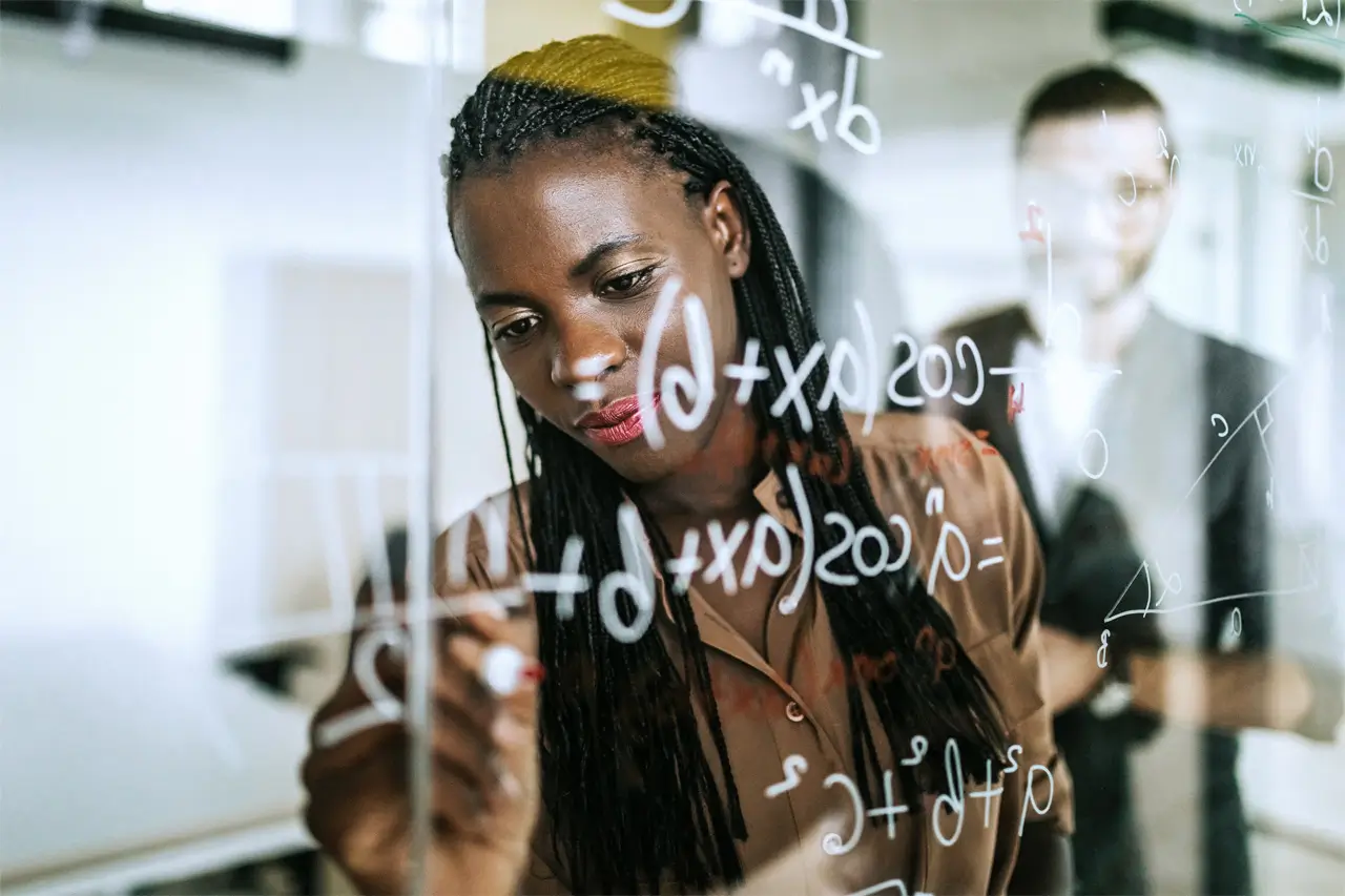 person writing on glass board