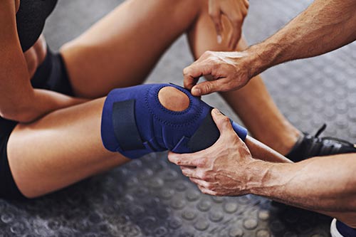 knee with person putting on a brace