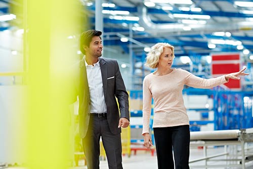 supply manager and employee walking through facility