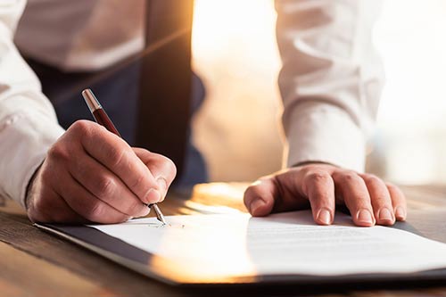 a hand signing a paper