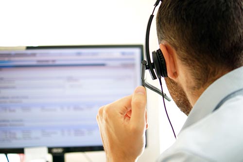 person on a headset looking at a computer screen